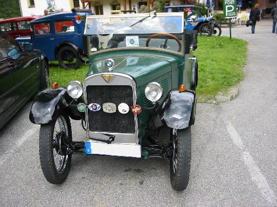 Dunkelgrüner, offener Kleinwagen von vorne gesehen.