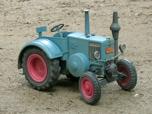 Der Traktor schräg von vorne gesehen auf der Gartenerde.