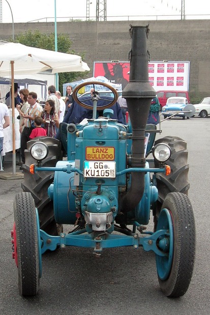 Ein blauer Traktor bei einer Oldtimer–Veranstaltung, von vorne gesehen.