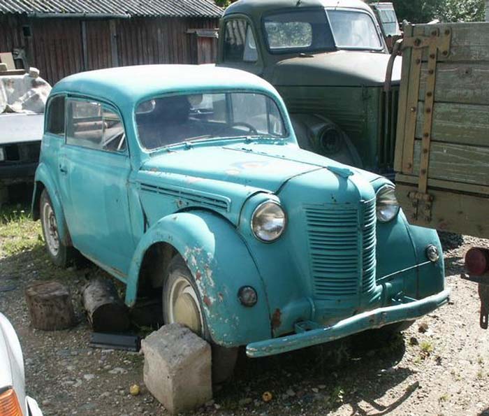 Foto: türkisfarbener, zweitüriger Opel Kadett auf Schrottplatz.