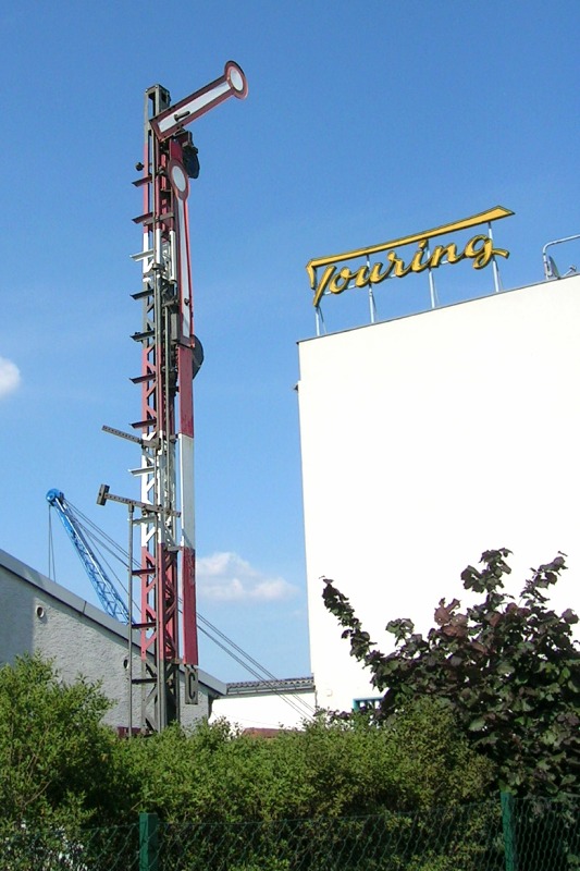 Rot–weiß–grau lackiertes Hauptsignal mit zwei Signalflügeln und Gittermast.