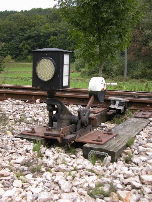 Stellbock und Weichensignal an einer Meterspurweiche.