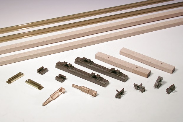 Im Hintergrund lange Schienen– und Schwellenprofile, im Vordergrund zahlreiche Kleinteile für den Gleisbau, auch Holz– und Kunststoff–Schwellen.