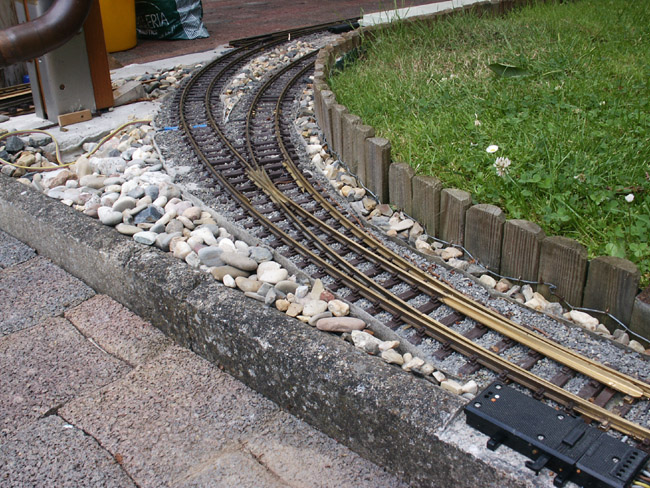 Eine Innenbogenweiche gabelt sich auf dem Schotterbett nach links hinten hin vom Betrachter weg. 