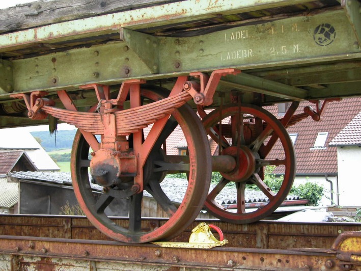 Rot gestrichene Achslagerkonstruktion an einem sehr alten Wagen.