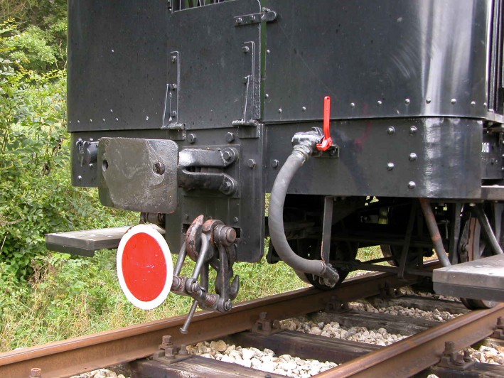 Pufferbohle an einem Personenwagen, mit rot–weißer Zugschlussscheibe.