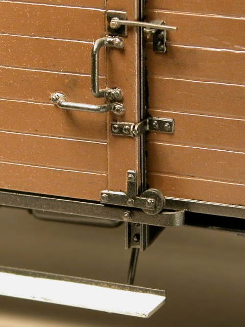 Großaufnahme der Beschlagteile, Riegel und Rollen an der Schiebetür eines gedeckten Güterwagens.