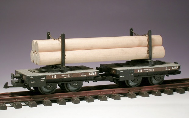 Modellfoto: zwei Flachwagen mit Drehschemeln und Holzstämmen aus einem Besenstiel als Ladung.