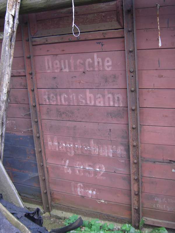 Reichsbahn–Beschriftung am verwitterten Wagemkasten eines gedeckten Güterwagens.
