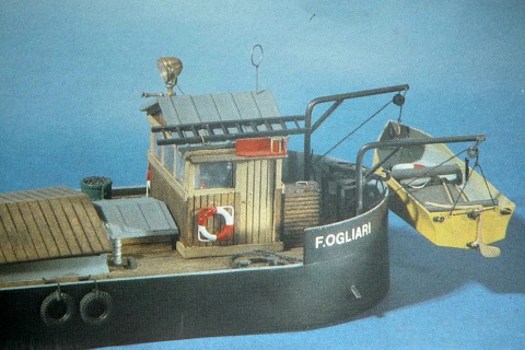 Das Heck eines kleinen Frachtschiffs mit einem Rettungsboot hinten.