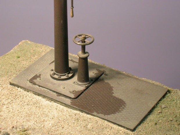 Modell: die Bodenplatte des Wasserkrans mit der Säule und dem Handrad des Hahns.